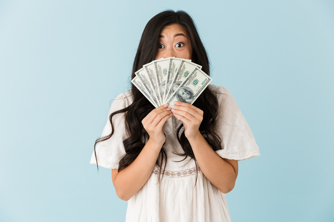 Beautiful Woman Isolated over Blue Background Holding Money.